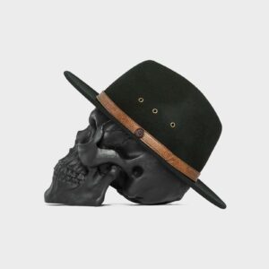 Billy Bones Club brand black fedora hat made from 100% wool felt with brown leather crown wrap. Being worn by a black skull mannequin head.